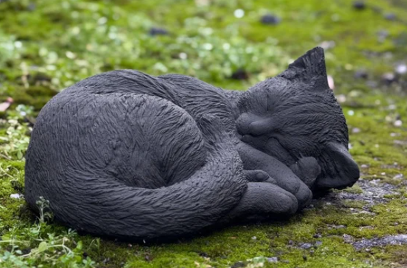 cat sleeping on statue